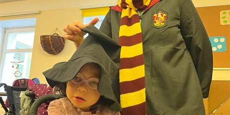 Powiększ grafikę: Dziewczynka w kapeluszu obok terapeutka w okularach i szaliku jako Harry Poter