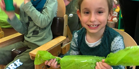 Powiększ grafikę: usmiechnięta dziewczynka trzyma wielki zielony cukierek - instrument muzyczny
