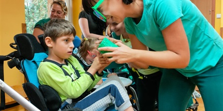 Powiększ grafikę: chłopczyk w zielonej koszulce trzyma zielony pojemnik
