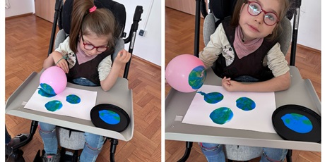 Powiększ grafikę: Dziewczynka na wózku maluje planety farbą naniesiona na balon