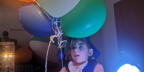 Powiększ grafikę: Marcelina trzyma sznurek z balonikami.
